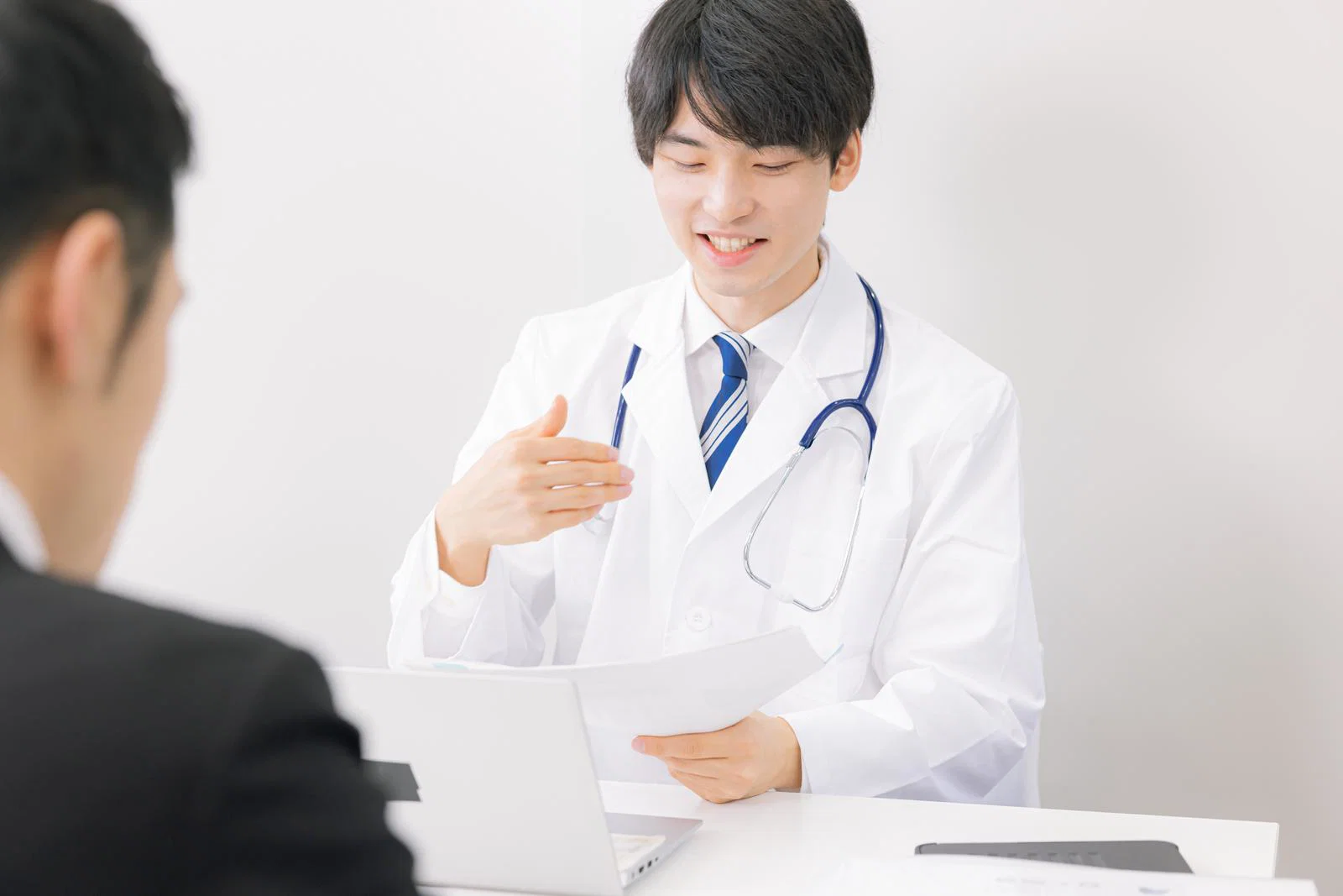医師が資料を手に相談者へ説明している様子